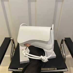 Sac bandoulière minimaliste en cuir blanc avec bandoulière nouée élégante en main