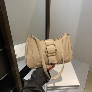 Retro apricot hobo bag with a gold square buckle shown in a lifestyle setting