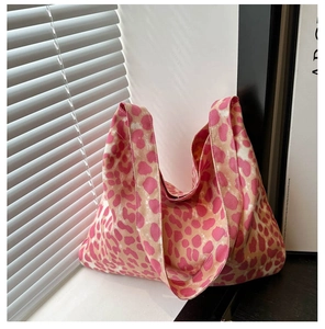 Detail of pink leopard print canvas tote bag showing soft texture by a sunlit window
