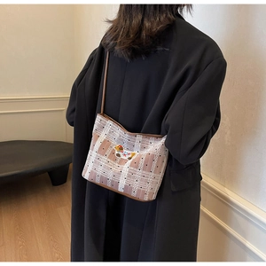 Détail du sac à bandoulière en tissu avec texture dentelle et broderie de chien