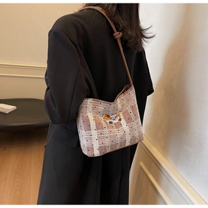 Gros plan du sac à carreaux rose avec broderie de chien et détail de bandoulière nouée