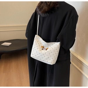 Détail du sac en toile à pois blancs orné d'un patch brodé d'un petit ours mignon