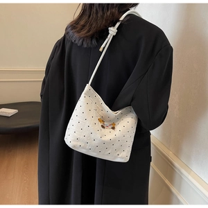 Détail du sac à pois blancs avec broderie animale et bandoulière en corde à nœuds