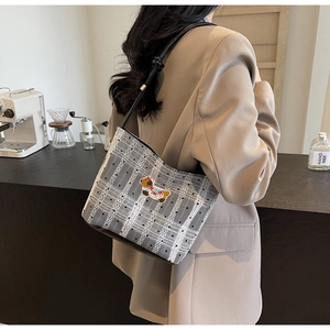 Détail du sac porté épaule à carreaux avec broderie chien et fine bandoulière noire