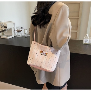 Détail d'un sac rose avec maille dentelle à pois et patch brodé d'un petit chiot