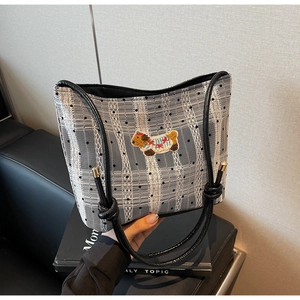 Détail du sac à main en dentelle à pois avec patch chiot et poignée en cuir nouée