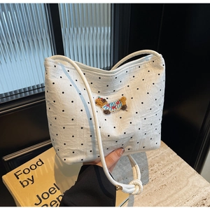 Détail du sac à bandoulière tissé blanc à pois noirs et broderie d'ours mignonne