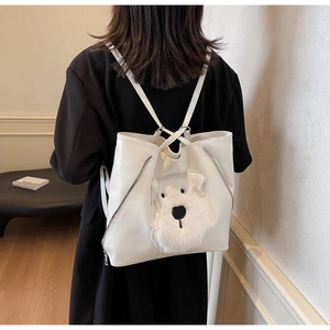 Detail shot of a white PU leather backpack featuring a 3D plush dog head and zip closure