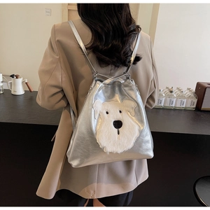 Detail of silver metallic backpack featuring a plush schnauzer dog patch with straps