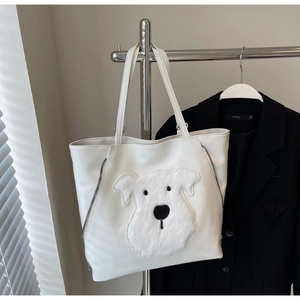 Detail of white PU tote bag featuring a plush dog patch and decorative side zippers