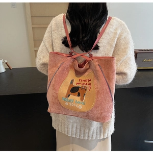 Détail d'un sac cabas en velours côtelé rose avec broderie chat et fermetures éclair