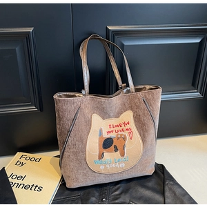 Détail du sac cabas en velours côtelé marron avec broderie chat et slogan sur fond rétro