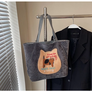 Détail du sac cabas en velours côtelé gris avec écusson de chat et fermeture éclair en métal