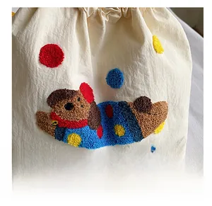 Détail de broderie bouclée avec animal mignon et pois colorés sur un sac fourre-tout