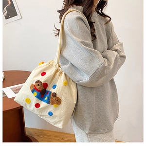 Détail de la broderie ours et points colorés sur un sac cabas en toile crème