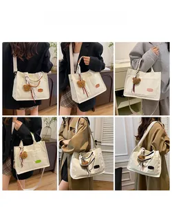 Detail view of cream canvas tote bag with multi-functional straps and cute bear charm