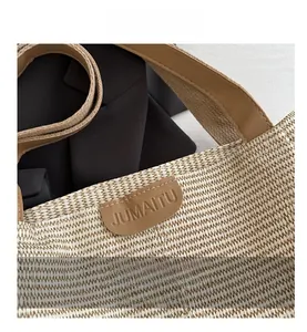 Détail d'un sac cabas tissé avec écusson en cuir marron et finitions de haute qualité