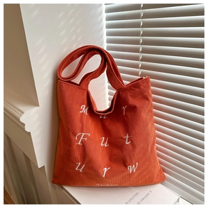 Detail view of orange corduroy tote bag featuring white MY FUTURE letter embroidery