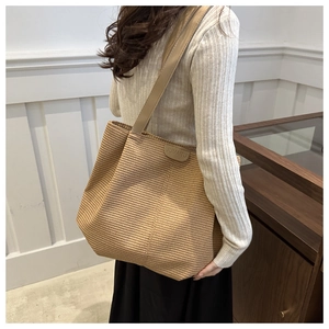 Détail de la texture tissée et de l'étiquette en cuir de ce grand sac cabas en paille