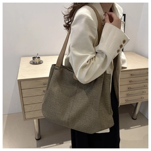 Détail de la texture tissée et de la bandoulière en cuir marron de ce grand sac cabas