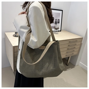 Gros plan sur la texture tissée et la bandoulière en coton d'un grand sac cabas