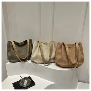 Vue détaillée des sacs cabas tissés en vert, beige et marron avec anses en cuir