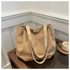Détail du sac cabas tissé avec logo JUMAITU en cuir et bandoulières beiges
