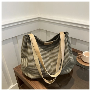 Gros plan sur la texture tressée du grand sac cabas avec logo en cuir sur table