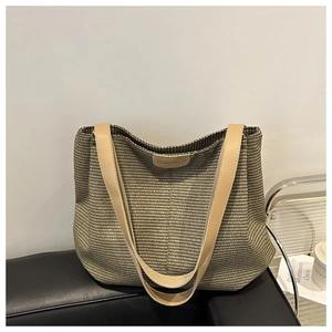 Gros plan sur la texture du sac cabas tissé avec logo en cuir et bandoulière