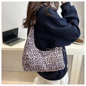 Detail view of leopard print shoulder bag showing fabric texture and slouchy crescent shape
