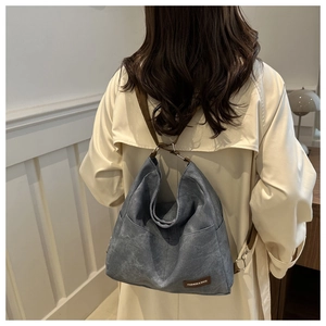 Detail of grey washed canvas Hobo bag showing the brown leather tag and texture
