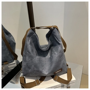 Detail of grey washed canvas tote bag featuring double front pockets and adjustable straps