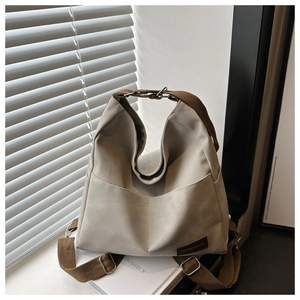 Detail of grey denim tote bag with brown straps and FASHION & BAGS logo patch