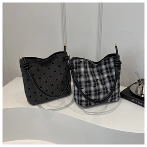 Detail of canvas bucket bags featuring black polka dots and plaid patterns with rope handles