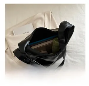 Macro view of the large capacity interior of a black PU leather tote bag with silver buckles