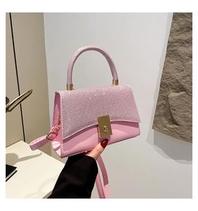 Dettaglio borsa rosa glitterata con chiusura a scatto dorata e tracolla regolabile