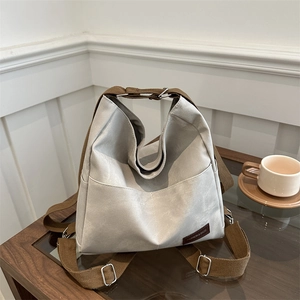 Versatile light gray denim backpack with adjustable brown straps for daily commuting