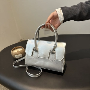 Minimalist silver faux leather handbag with sleek top handle and versatile crossbody strap