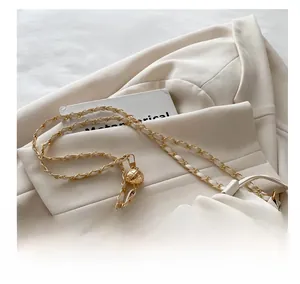Detail of white leather bag with gold chain strap and adjustable metallic ball buckle