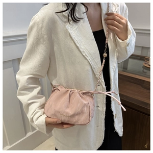 Detail of light pink pleated cloud bag with metallic chain and gold adjustment bead
