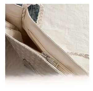 Détail de la fermeture éclair fluide et du tissu plissé du sac cabas blanc cassé