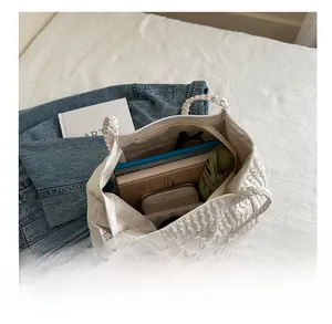 Détail intérieur du grand sac cabas blanc plissé montrant sa grande capacité pour les livres