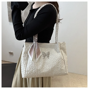 Détail du sac fourre-tout blanc plissé avec papillon argenté et foulard décoratif
