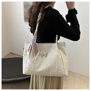 Détail du sac cabas plissé blanc crème avec breloque papillon et foulard en soie rose