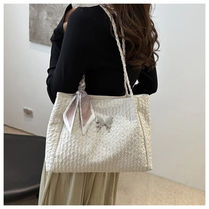 Détail du sac cabas plissé blanc avec fermoir papillon argenté et foulard en soie rose