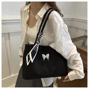 Détail du sac cabas plissé noir avec breloque papillon blanc et foulard en soie