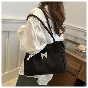 Détail du sac cabas plissé noir avec breloque papillon blanc et anses tressées
