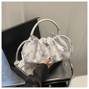 Detail of butterfly print pleated handbag with curved top handle and drawstring accents