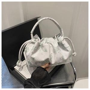 Detail view of white butterfly print tote bag with pleated design and knot decorations