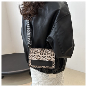 Close-up of leopard print crossbody bag with stylish geometric wide strap on a model